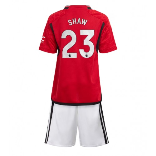 Otroški Nogometni dresi Manchester United Luke Shaw #23 Domači 2023-24 Kratek Rokav (+ Kratke hlače)